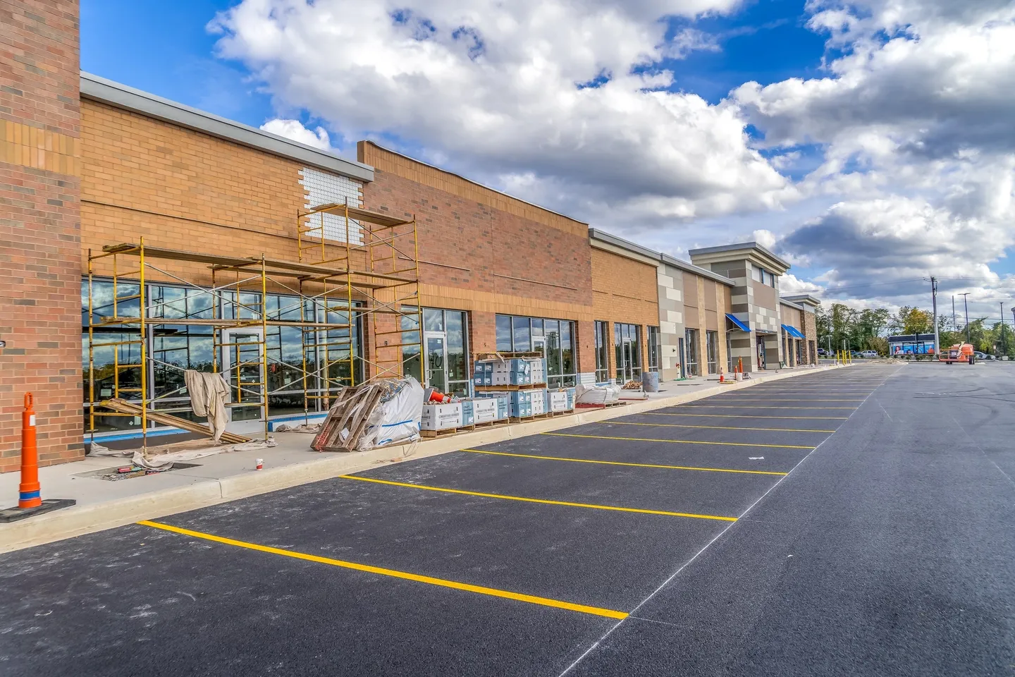 A large empty parking lot with several stores.