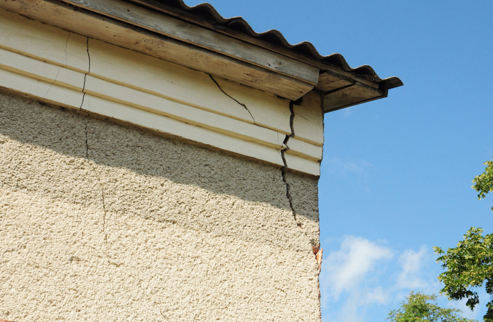 A cracked wall with cracks in it and blue sky