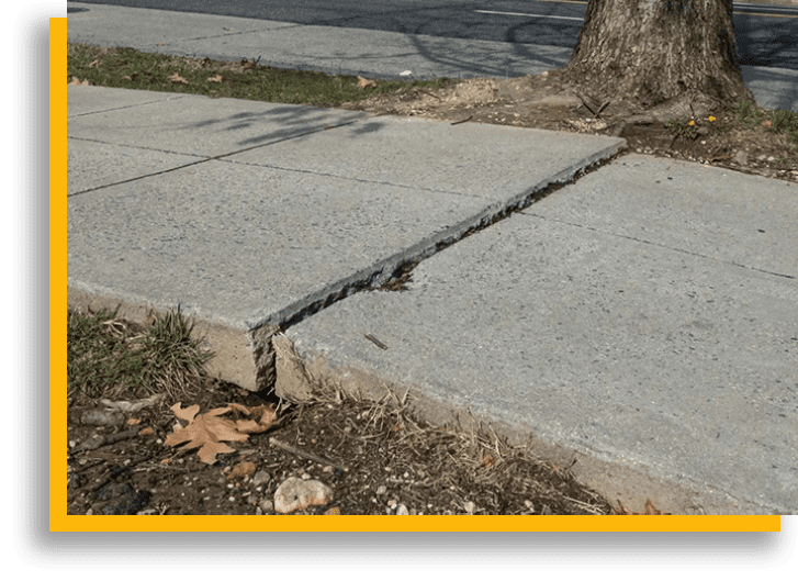 A sidewalk with concrete and asphalt on it.